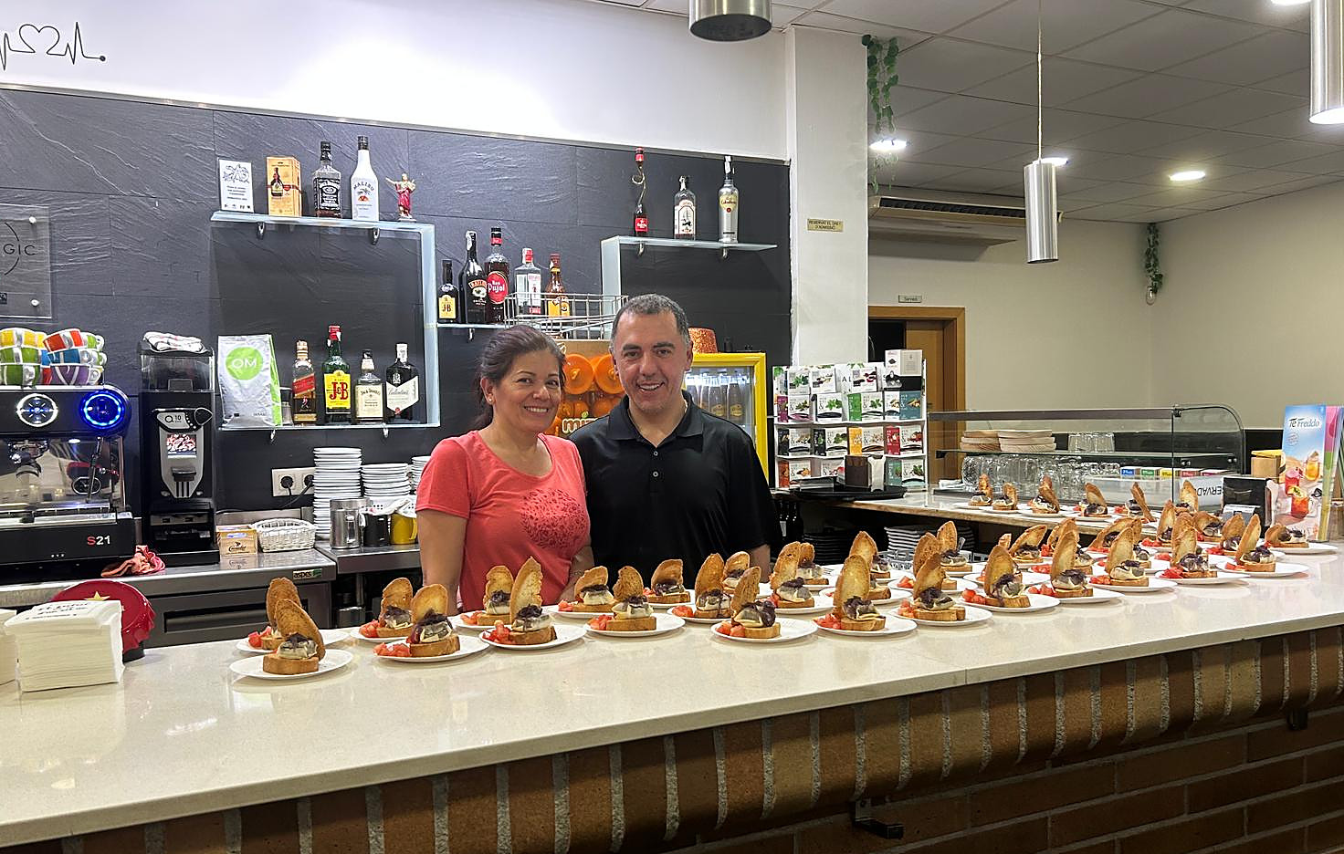 Los dueños de la panadería, sonriendo detrás de la barra